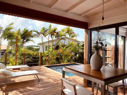 a dining room with a table and a view of a pool at ZANNANNA LODGE in Le Diamant