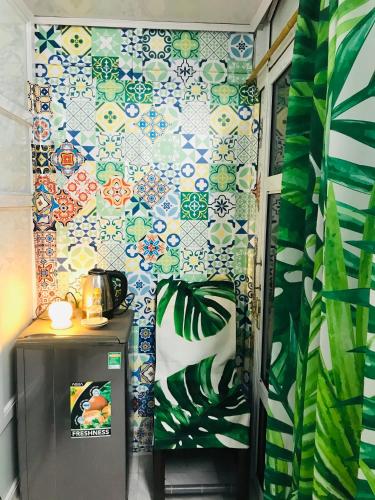 a bathroom with a wall covered in colorful tiles at Chicken's house- Đường Lâm Homestay in Hanoi
