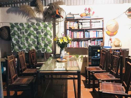a table and chairs with a vase of flowers on it at Chicken's house- Đường Lâm Homestay in Hanoi