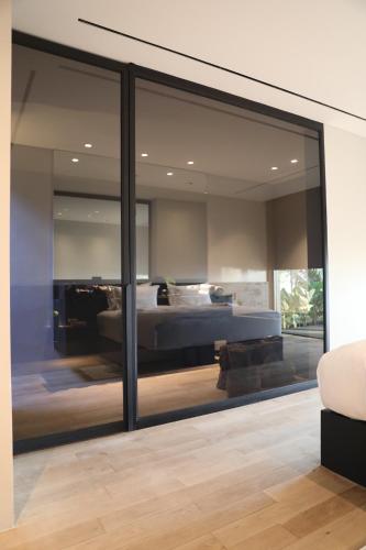 a bedroom with a bed and a large glass window at Lombok Private Villa Estate in Ketapang