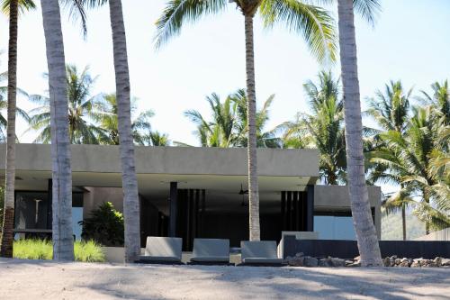a house on the beach with palm trees at Lombok Private Villa Estate in Ketapang