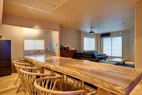 a kitchen and living room with a large wooden table at KONJAKUSO Osaka Tempozan "IKESU" Projection M apping SPA "TAKADORO" Wheel View in Osaka
