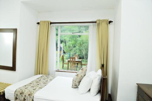 une chambre avec un lit et une fenêtre dans l'établissement Hotel Achivina, à Kandy