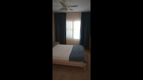 a bedroom with a bed and a ceiling fan at Room in Apartment - Kadinlar Denizi Ev 31 in Aydın
