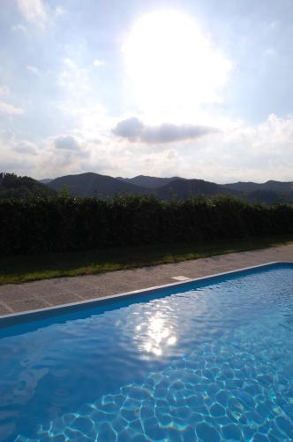 a blue swimming pool with mountains in the background at Podere Quartarola in Modigliana