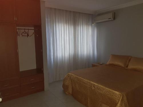 a bedroom with a bed and a dresser and a window at 2 munites walk to Ladies Beach in Aydın