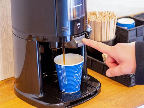 a person is pouring a coffee into a coffee maker at YU-FURI Nasu-Shiobara in Nasushiobara