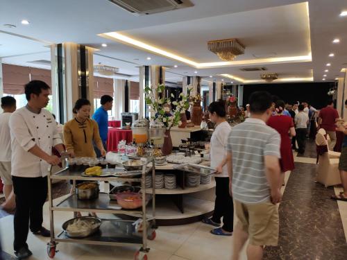 a group of people standing around a buffet in a restaurant at Muong Thanh Thanh Nien Vinh in Vinh