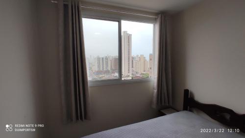 - une chambre avec une fenêtre offrant une vue sur la ville dans l'établissement Apto 2 Quartos c/ Suíte em Itaparica, à Vila Velha
