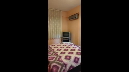 a bedroom with a bed and a television at 10 munites walk to City Center 10 munites walk to Ladies Beach in Aydın