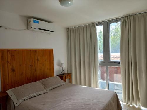 1 dormitorio con cama y ventana grande en Departamento Eutico en Villa Carlos Paz