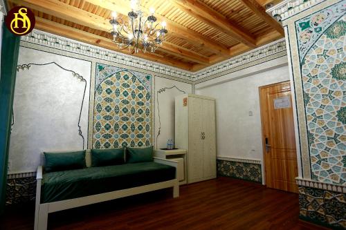 una habitación con un sofá verde en la esquina de una habitación en Shohnishin Boutique, en Bukhara