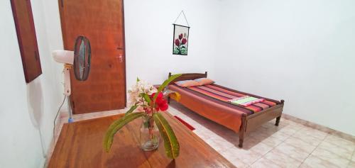 um quarto com uma cama e um vaso de flores em Dealings Freedom Rest em Gampola