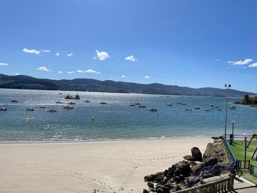 a beach with a bunch of boats in the water at Playa en las Rías Baixas - Raxó in Raxo