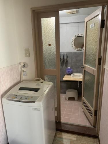 uma pequena casa de banho com uma máquina de lavar roupa e um lavatório em 山下ビル307 em Kurosakimachi
