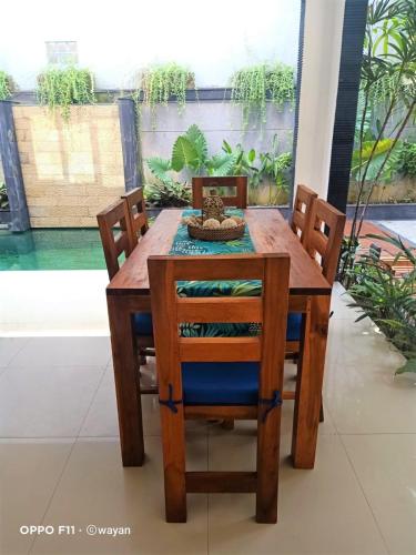a wooden dining room table with chairs and a table at Villa Tenang Legian in Legian