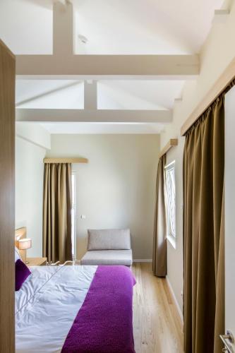 a bedroom with a bed and a purple rug at PATH Bonjardim Apartments in Porto