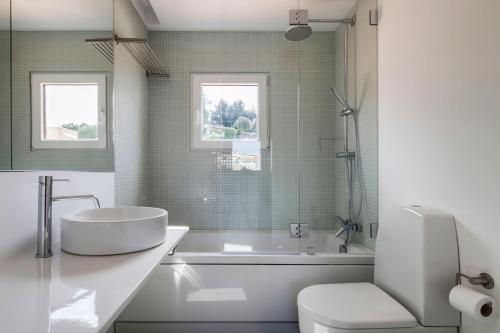 a bathroom with a tub and a sink and a toilet at PATH Bonjardim Apartments in Porto