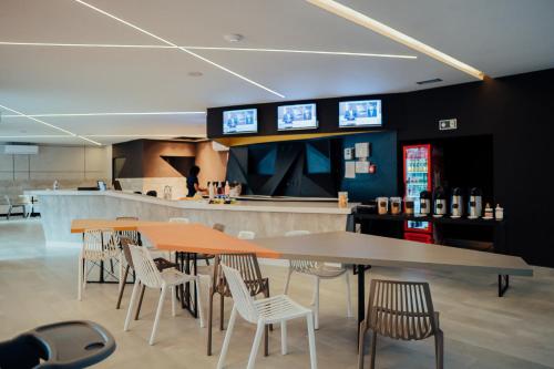 a restaurant with tables and chairs and a bar at Front Comfort Teófilo Otoni in Teófilo Otoni