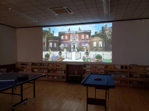 a large screen in a room with a large building at Mikan Hotel in Uwano