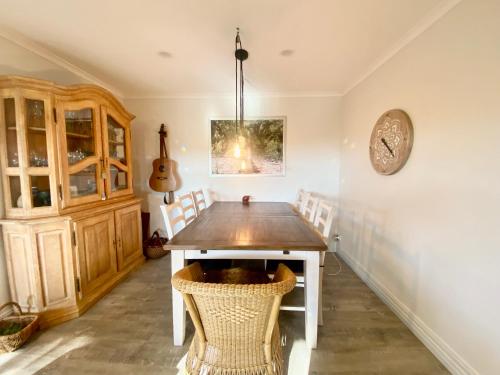 a dining room with a table and chairs at Palm Garden Beach House in Papamoa
