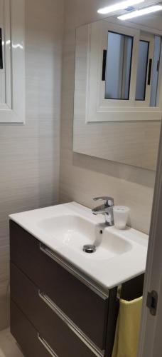 a bathroom with a white sink and a mirror at Barcelona, Apartamento de 2 habitaciones. in Hospitalet de Llobregat
