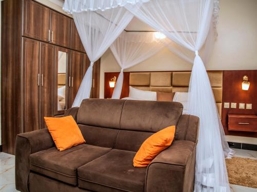 uma sala de estar com um sofá e uma cama em Studio Furnished Apartment Entebbe em Entebbe