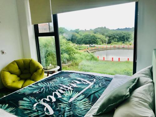 a bedroom with a large window with a bed and a chair at Yishan Village in Jincheng