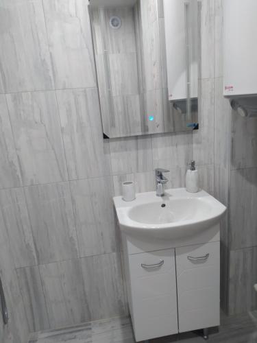 a white bathroom with a sink and a mirror at Raia in Stara Zagora