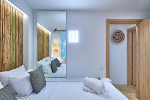 a bedroom with a large white bed and a mirror at Casa Mardiva Sole in Kampos Paros