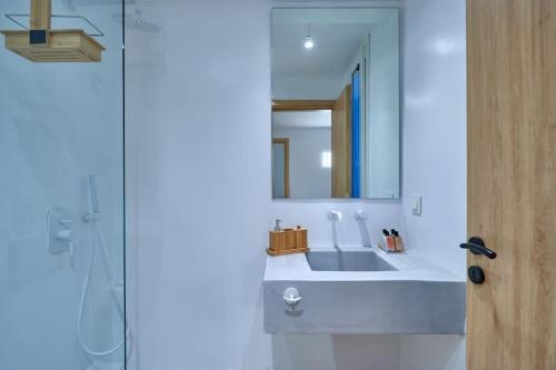a white bathroom with a sink and a mirror at Casa Mardiva Sole in Kampos Paros