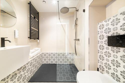 a bathroom with a shower and a toilet and a sink at De BrauHotel in Bascharage