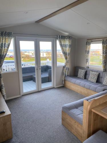 a living room with couches and a balcony at Sandy bay mariners rise in North Seaton