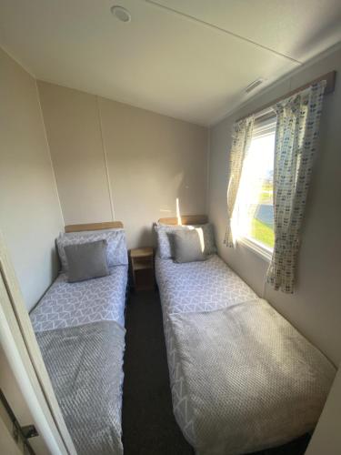 two beds in a small room with a window at Sandy bay mariners rise in North Seaton