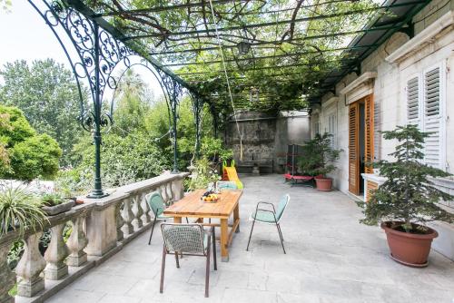an outdoor patio with a wooden table and chairs at Rooms Posat in Dubrovnik