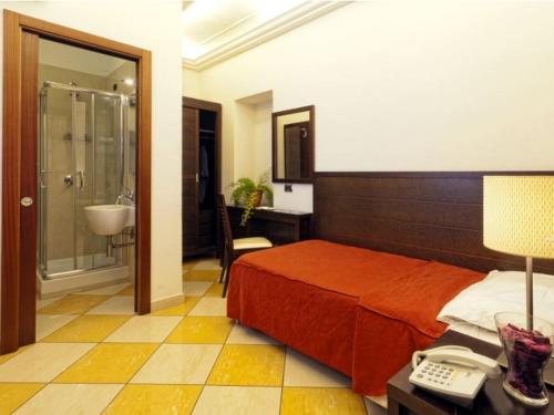 a hotel room with a bed and a bathroom at Albergo del Golfo in Naples