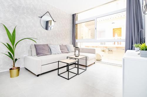 a living room with a white couch and a table at Cala de Mijas Summer Vibes in Mijas Costa