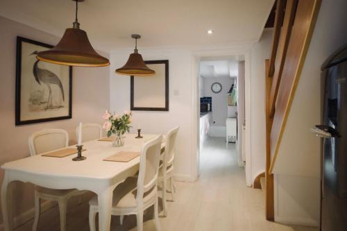 a dining room with a white table and chairs at Salt Life Cottage in Brighton & Hove