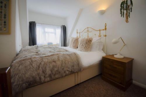 a bedroom with a large bed and a window at Salt Life Cottage in Brighton & Hove