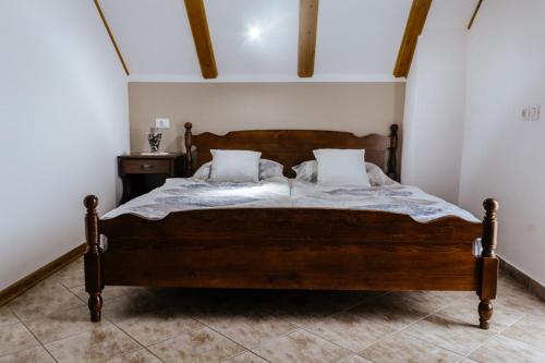 a bedroom with a large wooden bed with two pillows at Holiday Home Na Biru 1 in Tolmin