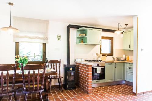a kitchen and dining room with green cabinets and a table at Holiday Home Na Biru 1 in Tolmin