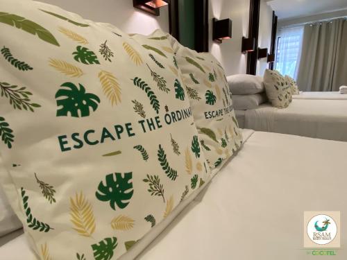 a bed with a pillow that says escape the ordinary at RSAM Beach Resort by Cocotel in Nasugbu