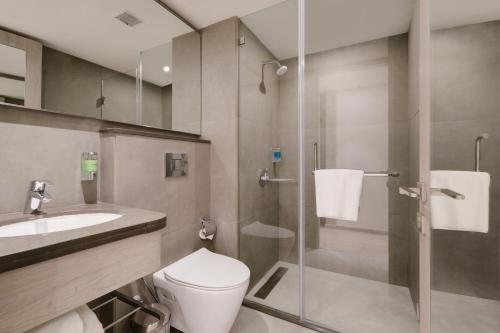 a bathroom with a toilet and a sink and a shower at 7 Apple Hotel Mahape, Navi Mumbai in Navi Mumbai