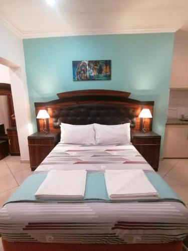 a large bed in a room with two lamps at Palm View Guest House in Pretoria