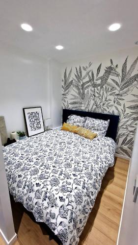 a bedroom with a bed with a black and white comforter at Unique au pied de la Tour Eiffel in Paris