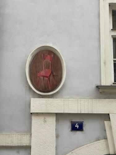 a red chair on the side of a building at U Cervene zidle - Red Chair Hotel in Prague