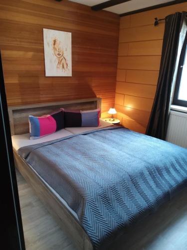 a bedroom with a bed with a wooden wall at Fewo Oehlenschlaeger Nr 53 Eg in Arrach