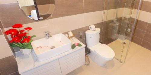 a bathroom with a sink and a toilet with red flowers at Huy Đạt Hotel in Phan Thiet