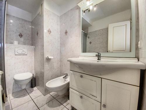 une salle de bain avec un lavabo, des toilettes et un miroir dans l'établissement Imperial Croisette FER3417 studio, à Cannes