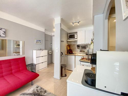 un salon avec un canapé rouge et une cuisine dans l'établissement Imperial Croisette FER3417 studio, à Cannes